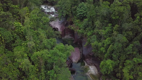 In-a-slow-motion-aerial-view,-the-Babinda-Boulders-in-Cairns,-Australia-reveal-swift-creeks-and-dense-forests-intertwining-with-massive-granite-formations,-offering-insight-into-its-serene-name