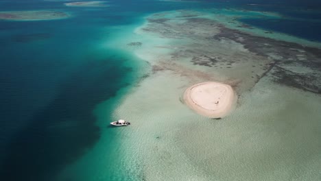 Un-Dron-Disparó-A-Un-Pequeño-Atolón-Rodeado-De-Un-Brillante-Océano-Turquesa,-Patrimonio-Mundial-De-Los-Roques.