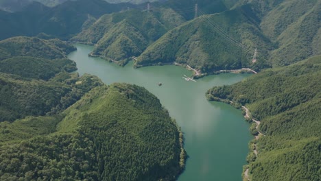 Aerial-turquoise-water-lake-landscape-between-cedar-forest-in-Kyoto-Japan-Kansai-natural-environment-establishing-panoramic-drone-view
