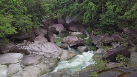 Desde-Un-Relajado-Punto-De-Vista-Aéreo,-Observamos-Los-Cantos-Rodados-De-Babinda-En-Cairns,-Australia,-Destacando-Las-Rápidas-Corrientes-Que-Fluyen-Entre-Sus-Estructuras-De-Granito,-Abrazadas-Por-Un-Verde-Follaje.