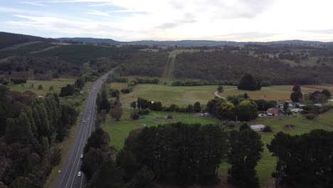 Dron-Descendiendo-Mostrando-Un-Importante-Camino-Rural-En-Australia-Con-Una-Granja-Al-Fondo