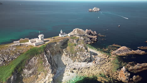 Vista-Aérea-Con-Plataforma-Rodante-Hacia-Abajo-De-Un-Faro-En-La-Costa-Escarpada