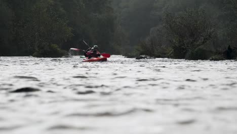 Paddeln-Auf-Einem-Regnerischen-Fluss,-3-Kajakfahrer-Navigieren-In-Zeitlupe-Durch-Den-Nieselregen