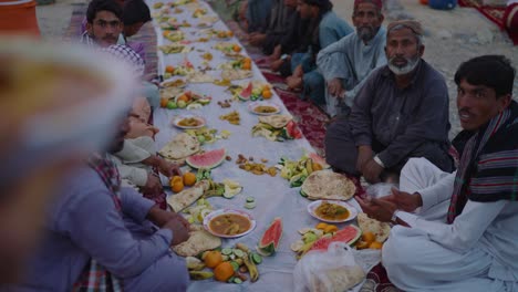 Fila-De-Lugareños-Sentados-Afuera-Junto-A-La-Comida-Durante-El-Ramadán-Iftar-Drive-En-Khuzdar-Baluchistán