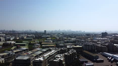 Un-Extenso-Paisaje-Urbano-Bajo-Un-Cielo-Despejado,-Que-Muestra-Densas-Estructuras-Urbanas,-Vista-Aérea