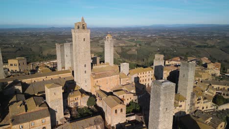 Forward-Drone-Flight-Above-San-Gimignano-with-Beautiful-Tuscan-Landscape-in-Background