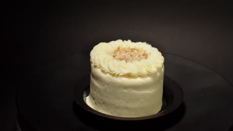 mini-petite-individual-personal-slice-portion-of-Carrot-cake-with-creme-cover-and-nuts-in-a-turn-table-black-background-isolated-delicious-healthy-vegetable-sweet