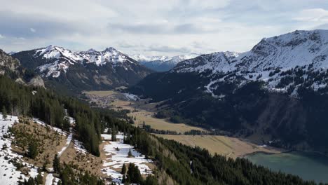 Captado-Desde-Arriba,-Tirol-Tannheimer-Tal-Revela-Sus-Picos-Montañosos-Cubiertos-De-Nieve-Y-Un-Tranquilo-Lago-Ubicado-Debajo,-Mostrando-El-Sereno-Paisaje-Suizo.