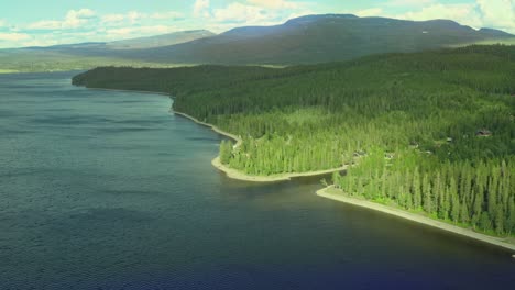 Drohne-über-Einem-See-Mit-Wald,-Bergen-Und-Himmel