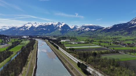Traffic-on-highway,-agricultural-farm-fields-and-Rhine-River-between-Switzerland-and-Liechtenstein-Country