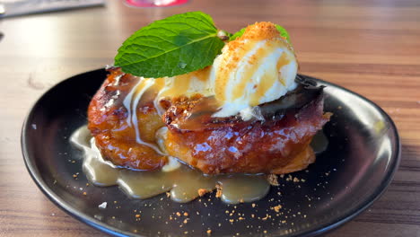 Tasty-pain-perdu-French-toast-with-vanilla-ice-cream-and-fresh-mint-leaves-on-a-plate,-sweet-dessert-at-a-restaurant,-4K-shot