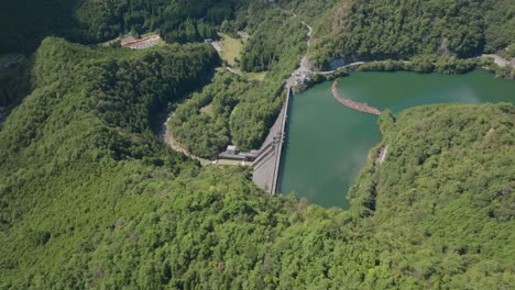 Aerial-Drone-fly-above-Dam-in-kyoto-blue-water-landscape-quiet-river-flow-at-zen-green-cedar-forest,-Japanese-Japan-natural-environment-in-Kansai-daylight