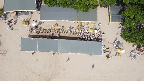 Aerial-view,-procession-on-Samuh-beach-during-the-Melasti-ceremony-before-the-silent-day-of-Nyepi