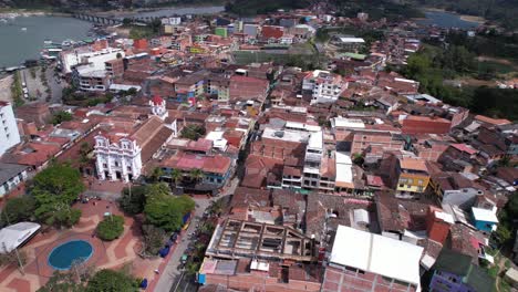 Aerial-View-of-Guatape-Town,-Antioquia-Colombia,-Church-and-Downtown-Buildings,-Drone-Shot