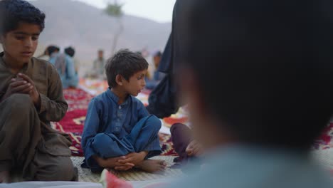 Niños-Sentados-Afuera-Antes-De-Cenar-Juntos-Iftar-Durante-El-Ramadán-En-Khuzdar,-Baluchistán