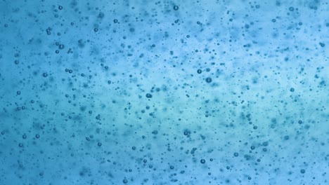 Multitude-of-blue-bubbles-in-sparkling-water,-light-colored-background,-packshot