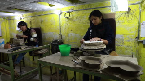 Mexican-craftswoman-working-with-a-large-piece-of-clay-in-order-to-create-a-heart-shaped-craft