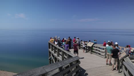 Sleeping-Bear-Sand-Dunes-National-Lakeshore-overlook-of-Lake-Michigan-in-Michigan-with-people-on-wooden-overlook-and-video-panning-left-to-right