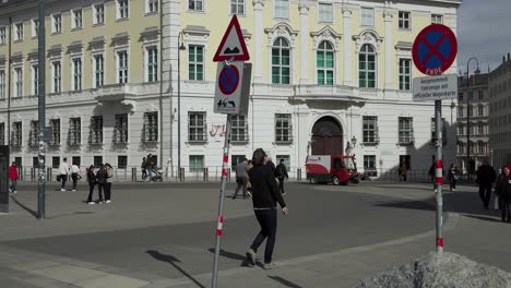 Toma-En-Cámara-Lenta-De-Turistas-Caminando-Frente-A-Un-Edificio-Histórico-En-La-Hermosa-Viena,-Austria