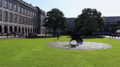 Die-Alte-Bibliothek-Des-Dublin-Trinity-College-Steht-Im-Gegensatz-Zu-Einer-Zeitgenössischen-Skulptur-Auf-Dem-Campus