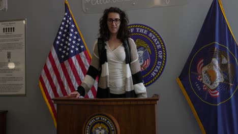 Woman-Stand-Behind-Lectern-With-Seal-of-Utah-At-State-Capitol-Building-In-Salt-Lake-City,-Utah