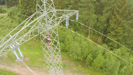 Arbeiter-Klettern-Hochspannungsmast-Im-Wald,-Luftaufnahme