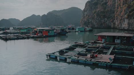 Sailing-Past-Traditional-Vietnamese-Boats-and-Floating-Village-Among-Beautiful-Limestone-rocks-of-Lan-Ha-bay,-the-southern-edge-of-Ha-Long-bay