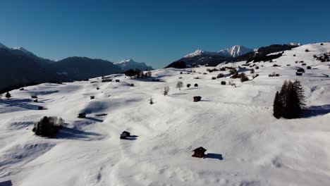 Casas-De-Madera-En-El-Paisaje-Alpino-Con-Nieve,-Antena