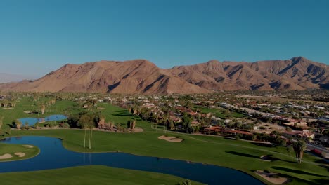Drone-shot-pulling-back-over-palm-springs-golf-course-and-luxury-neighborhood