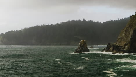 Pan-right-revealing-rocky-cliffs-along-Oregon-Coast-battered-by-Pacific-Ocean