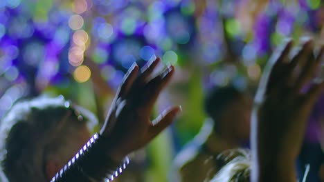 Rack-focus-between-group-of-drummers-in-blue-headdress-at-night-to-hands-waving-during-Carnival