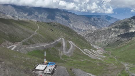 A-drone-retreats-upwards-over-Babusar-Pass,-revealing-the-sweeping-vistas-and-rugged-terrain-of-this-stunning-mountain-pass-in-Northern-Pakistan