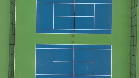 Several-empty-blue-colored-tennis-courts-outdoors-in-american-town
