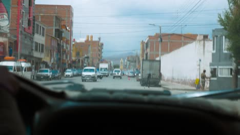 Fahrt-Durch-Die-Straßen-Von-Uyuni-Mit-Sichtbaren-Geschäften-Und-Geschäftigem-Verkehr,-Tagsüber,-Stadtszene,-Dashcam-Ansicht