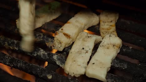 Rechte-Hand-Dreht-Halloumi-Käse-Finger-Am-Lagerfeuer-Im-Freien-Bei-Nacht