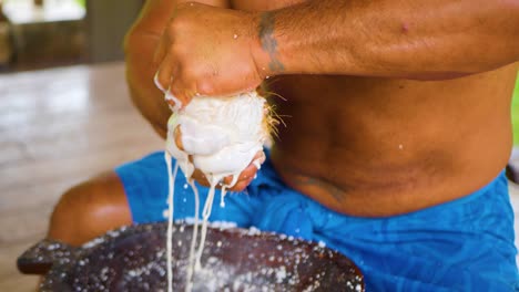 Extracting-creamy,-velvety,-and-luscious-coconut-milk-by-squeezing-coconut-pulp-with-strong-hands