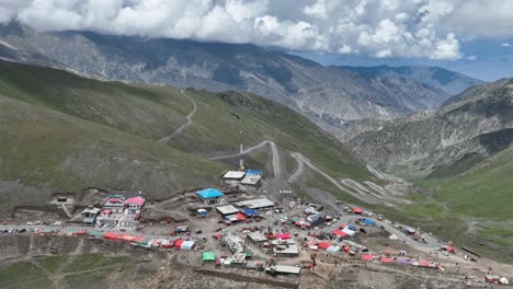 A-drone-retreats-upwards-over-Babusar-Pass,-revealing-the-sweeping-vistas-and-rugged-terrain-of-this-stunning-mountain-pass-in-Northern-Pakistan