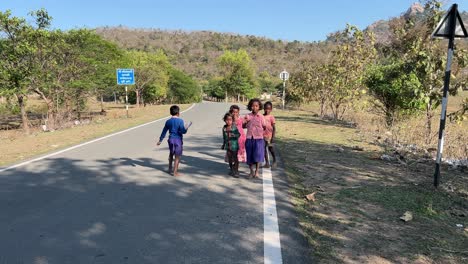 Tribal-children-playing-in-roads-in-a-village-in-Jharkhand-with-forest-and-mountains-in-the-background