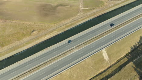 Zwei-Autos-Fahren-Auf-Einer-Offenen-Autobahn-Und-Werfen-Lange-Schatten-Im-Warmen-Licht