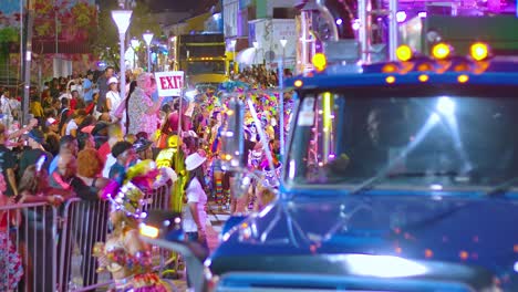 Blinkende-Lichter-Von-Lastwagen-Fahren-Durch-Die-Straßen-Während-Der-Karnevalsparade-In-Der-Nacht