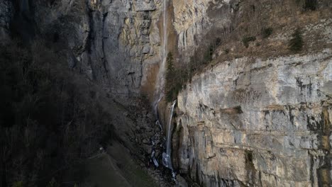 Soaring-above,-behold-the-majestic-allure-of-rugged-mountain-landscapes-embellished-with-cascading-waterfalls,-nestled-near-Walensee-Unterterzen,-Switzerland