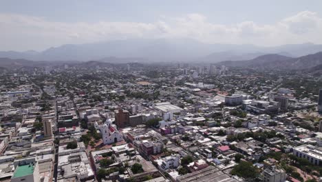 Santa-Marta-cityscape-in-Colombia,-tropical-city-on-Caribbean-coast,-mountain-range,-aerial