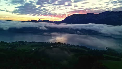 Luftaufnahme-Eines-ätherischen-Sonnenuntergangs,-Drohnenschwenk-über-Dem-Bergsee,-Bergsilhouette-Zeigt-Lebendige-Skyline