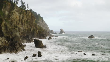 Pacific-Ocean-waves-breaking-against-rocks,-cliffs-on-Oregon-Coast,-through-fog