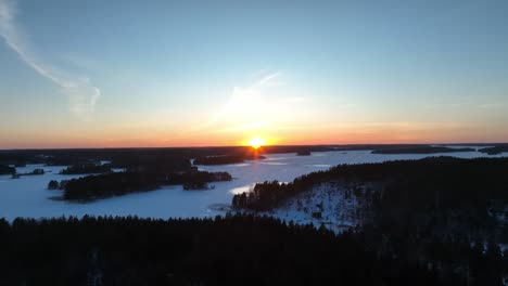 Vídeo-De-Drones-Sobre-Un-Bosque-Y-Un-Lago-Congelado-Al-Atardecer