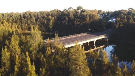 Una-Motocicleta-Pasa-Por-Un-Puente-En-Un-Suburbio-Boscoso-De-Australia