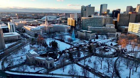 Sunset-aerial-dolly-over-snowy-Denver-Civic-Center-Park-during-Christkindlmarket