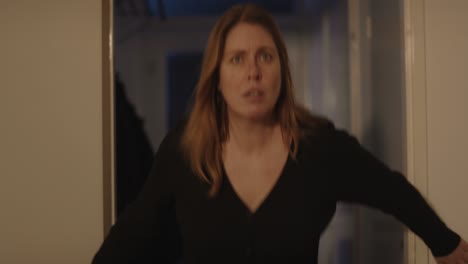 Frightened-woman-looking-at-something-off-screen,-she-gets-scared-and-flees-her-home