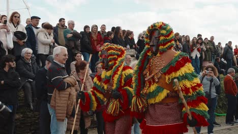 Carnival-revelers-in-vibrant-Careto-costumes,-Podence-Portugal