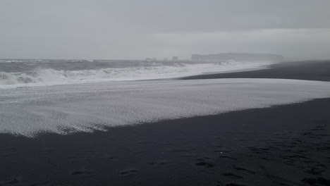 Rough-Sea-Waves-Crashing-on-Reynisfjara,-Black-Sand-Beach,-Coastline-of-Iceland-on-Cold-Rainy-Day